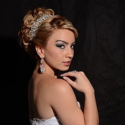 Brautfrisuren und Kosmetik Ein Bild auf der Seite 'Leistungen' verlinkt zur Kategorie 'Brautfrisuren und Kosmetik' und zeigt eine Braut mit einer makellosen Frisur und einem eleganten Make-up, perfekt für ihren besonderen Tag.