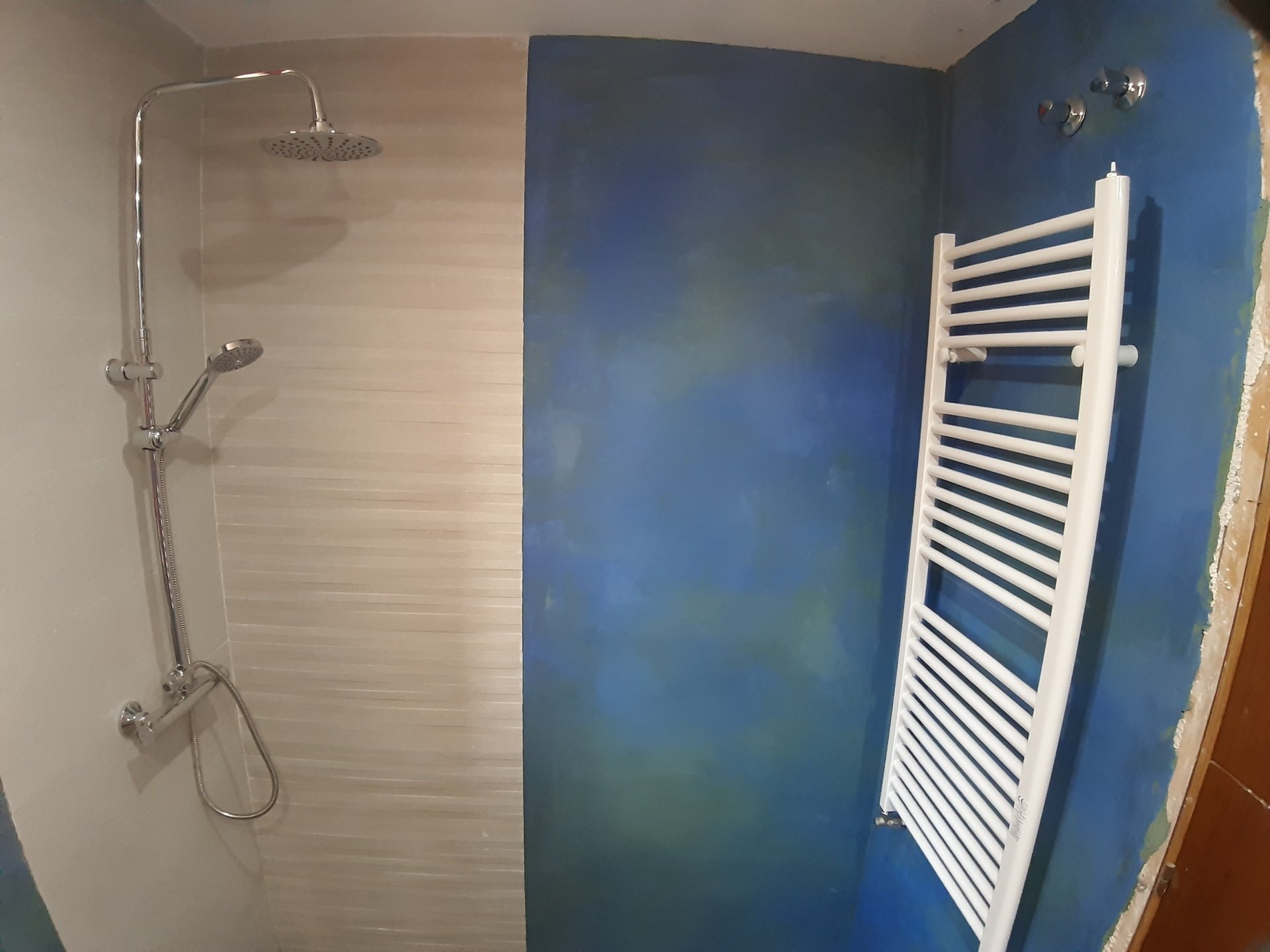 Reforma de baño alicatado y en la paredes revestimiento de Tadelakt en color azul con fondo verde