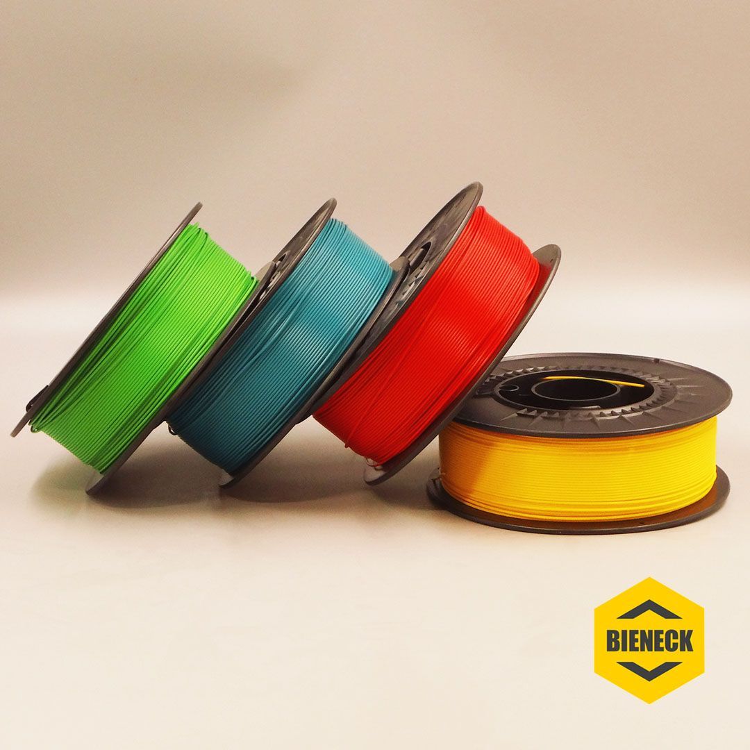 Filamentrollen in den Maschinenfarben gelbgrün, blau, rot, gelb