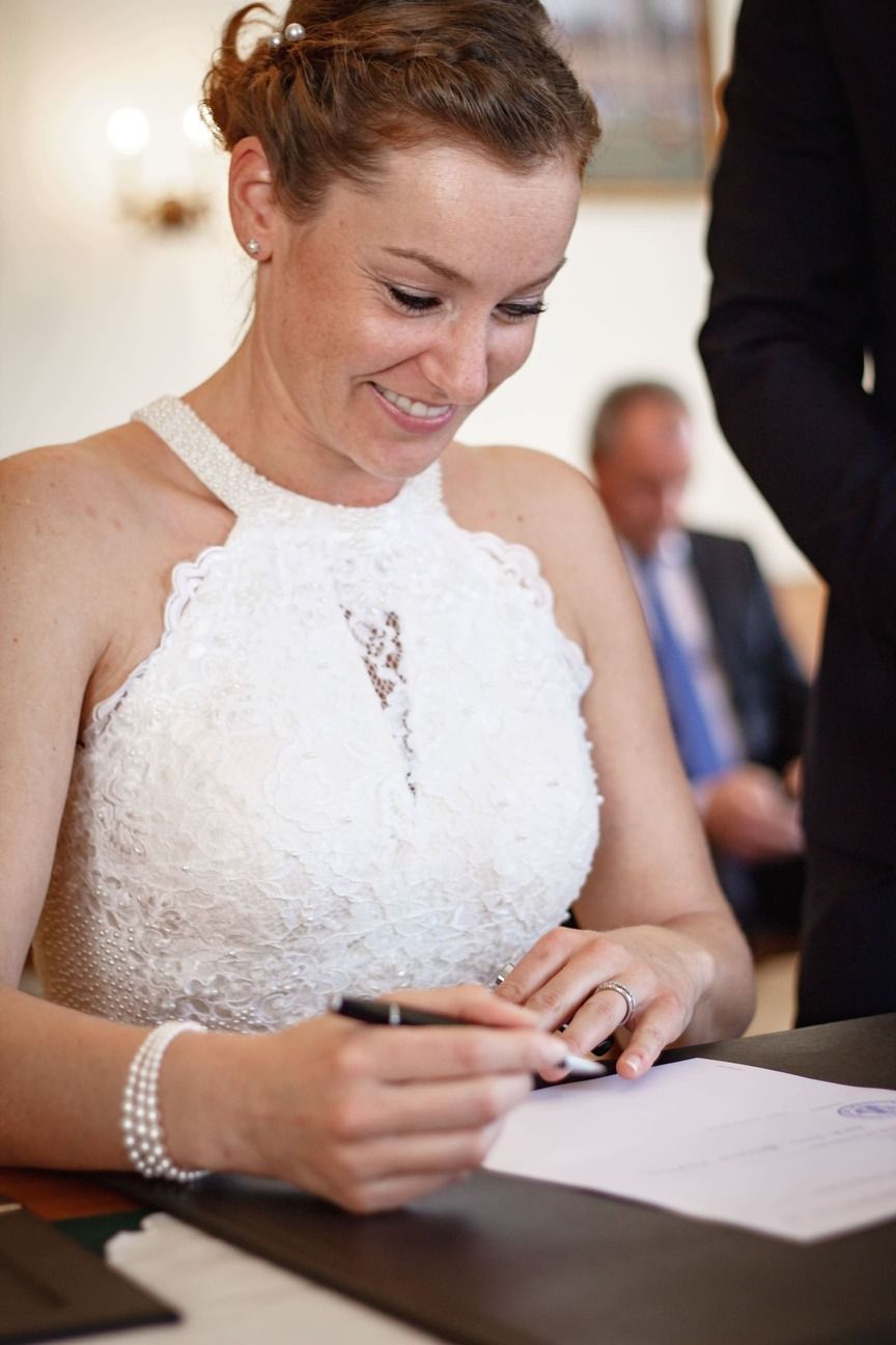 Nahaufnahme von Lucile bei der Unterzeichnung der Urkunde im Standesamt.