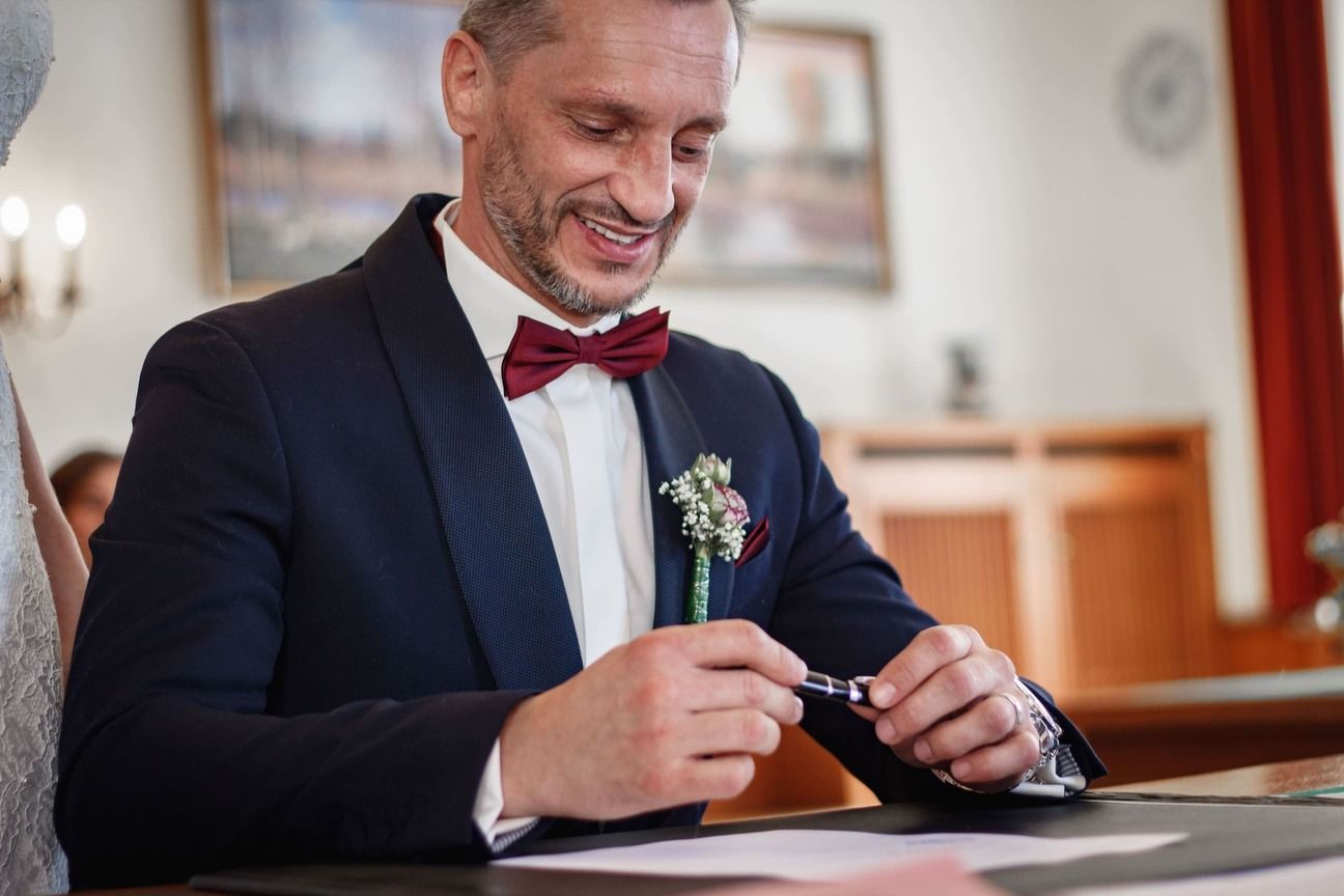 Nahaufnahme von Luciles Mann Lorand bei der Unterzeichnung der Urkunde im Standesamt.