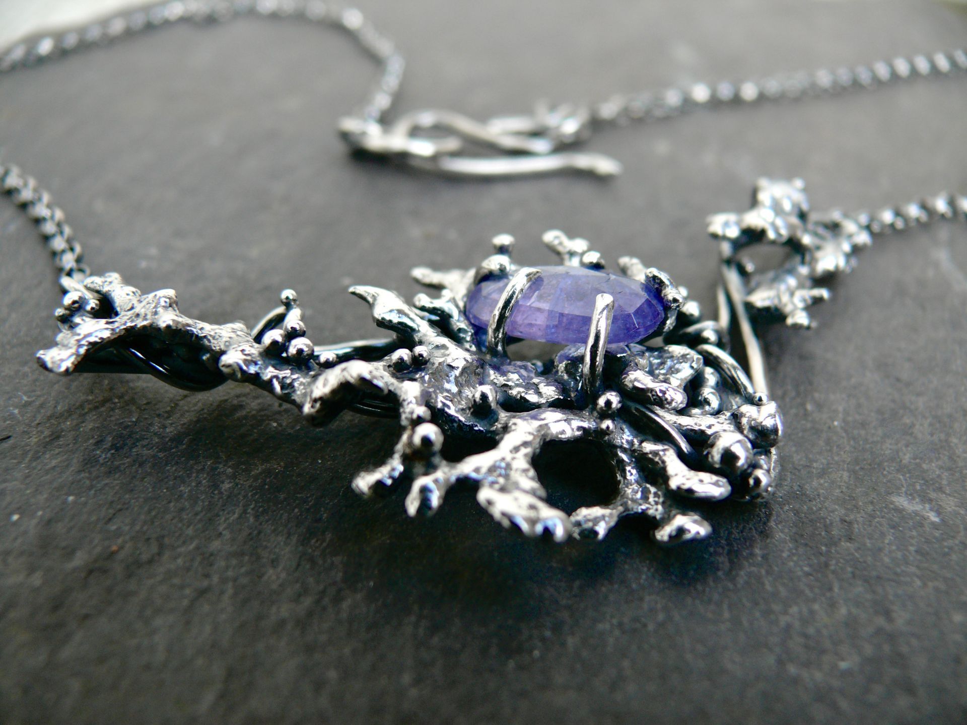 Necklace handmade in scotland with ethical tanzanite and purple gemstone. Features coral design, handcast from coral found on a scottish beach