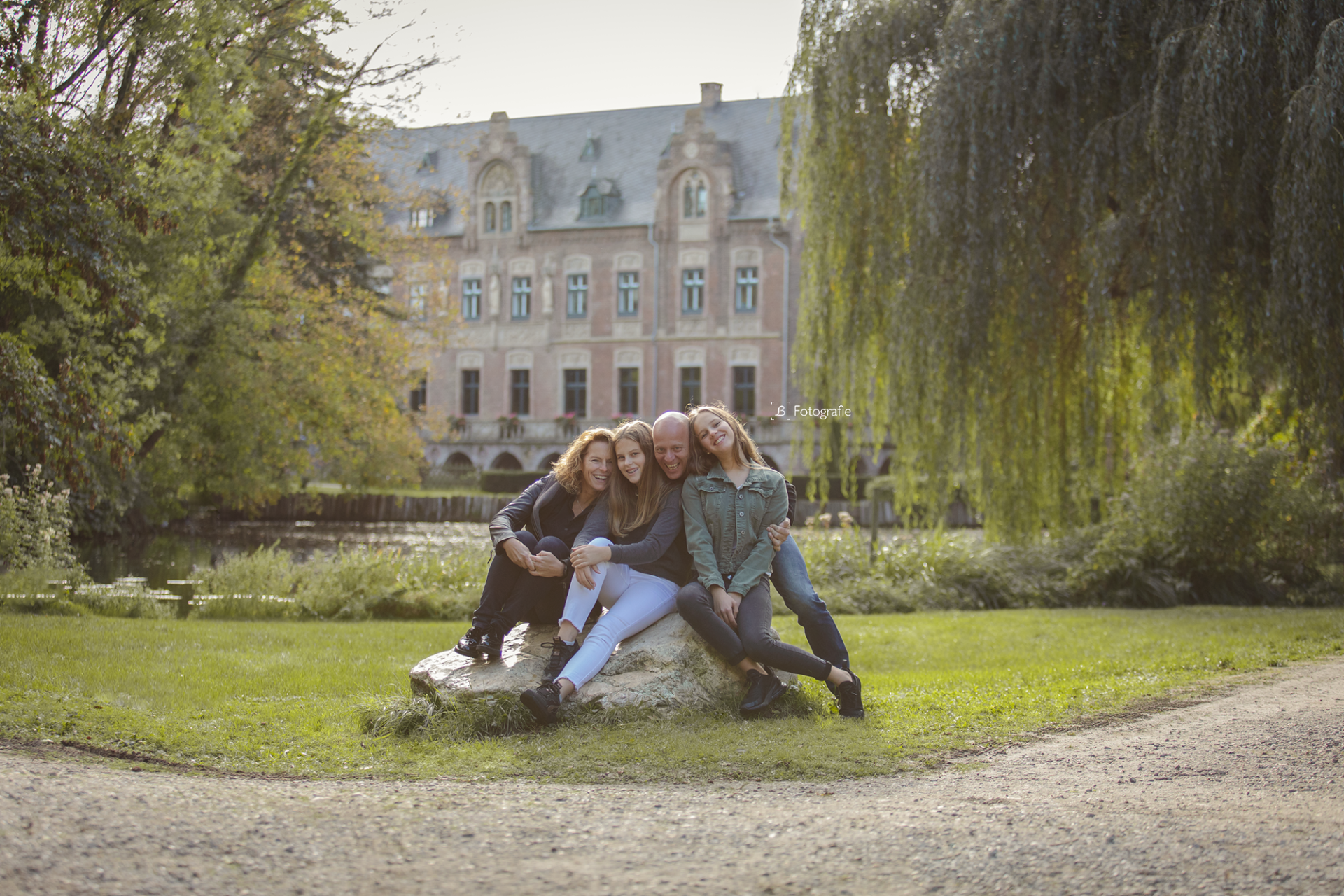 Familie posiert auf einem Stein vor dem Paffendorfer Schloss