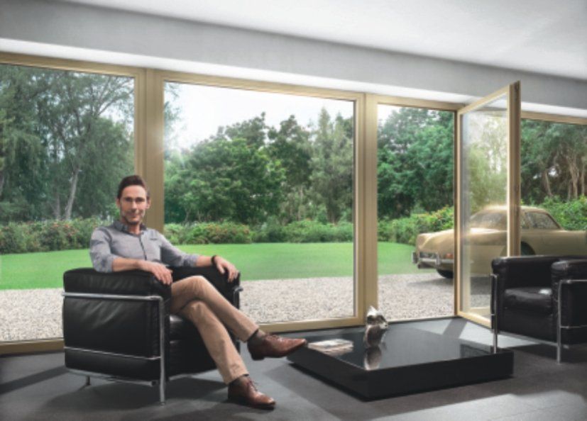 Bild und Link Ein Mann sitzt im Wohnzimmer vor einer Schiebetür