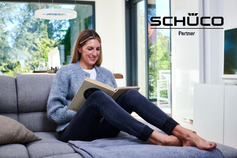 Eine Frau sitzt gemütlich im Sessel und liest ein Buch