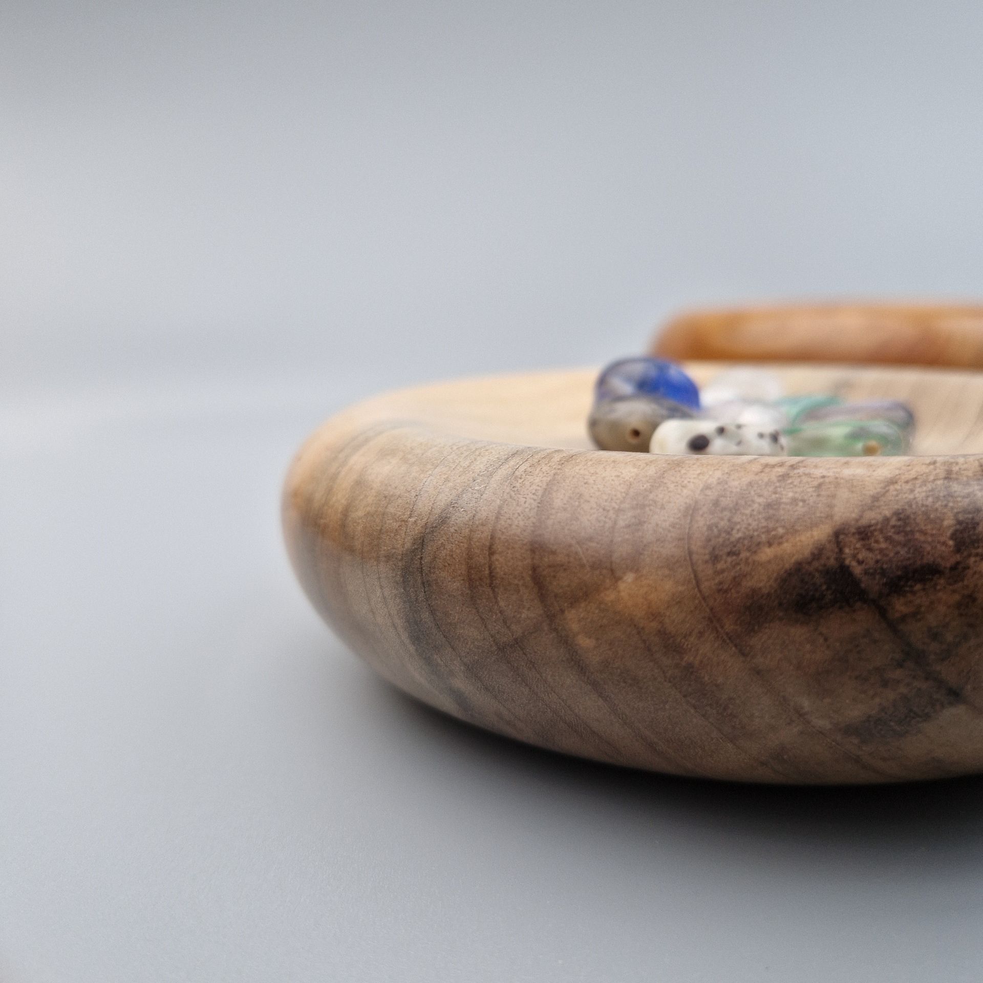 Trinket Cushions Side profile of rounded shape of trinket pillow with some beads and buttons nestled on the surface.