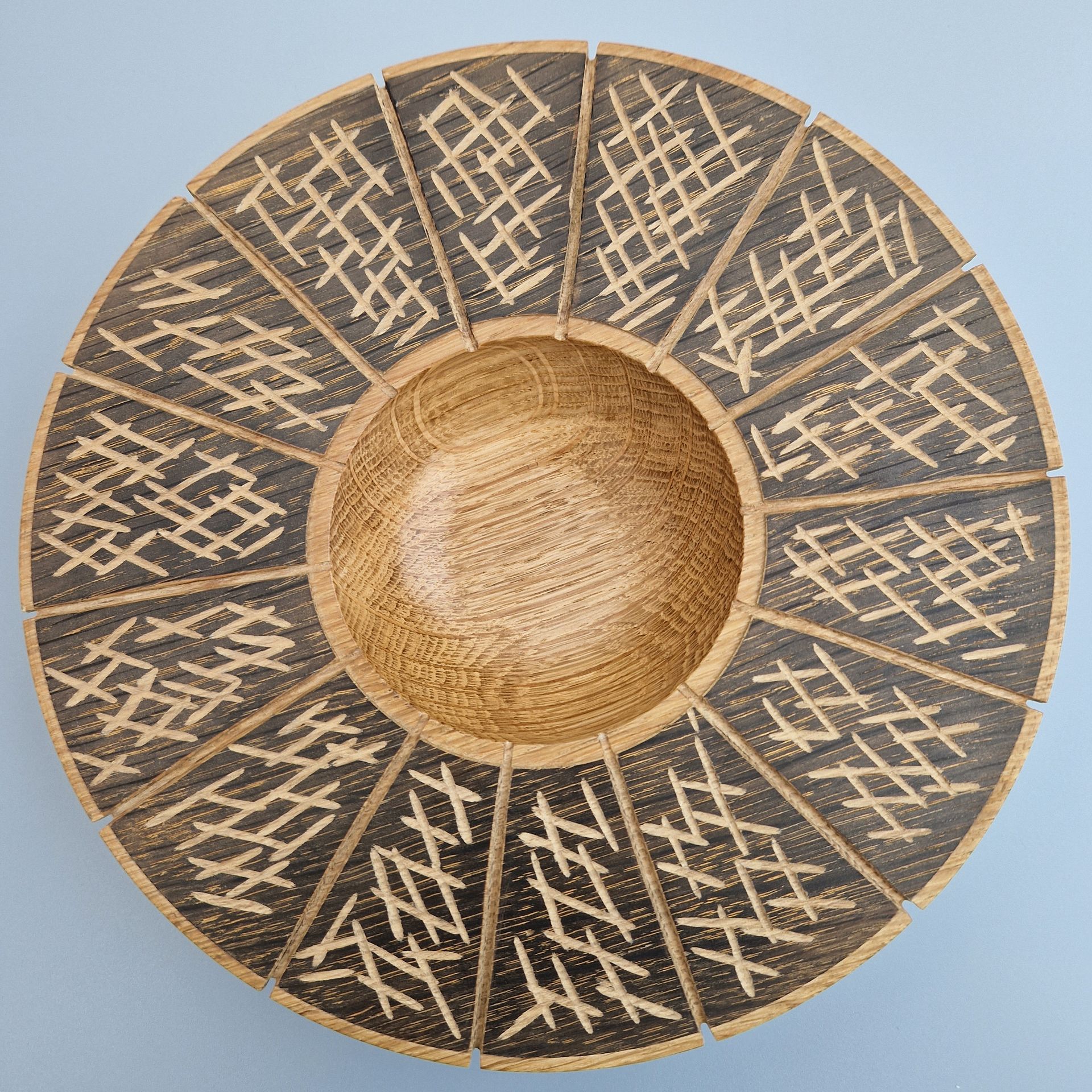 Large Oak Bowl Large oak bowl with broad rim ebonized, divided into 14 sections and carved with random marks.
Plain wood in the centre.