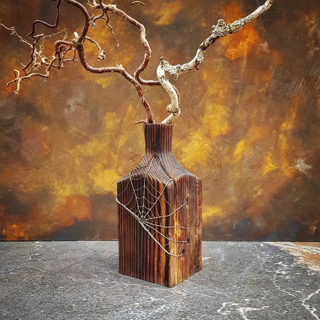 Fence Post Twig Pot Darkened twig pot, turned from old fence post, with wire spider web decoration. Holding curly twigs and cobwebs.
