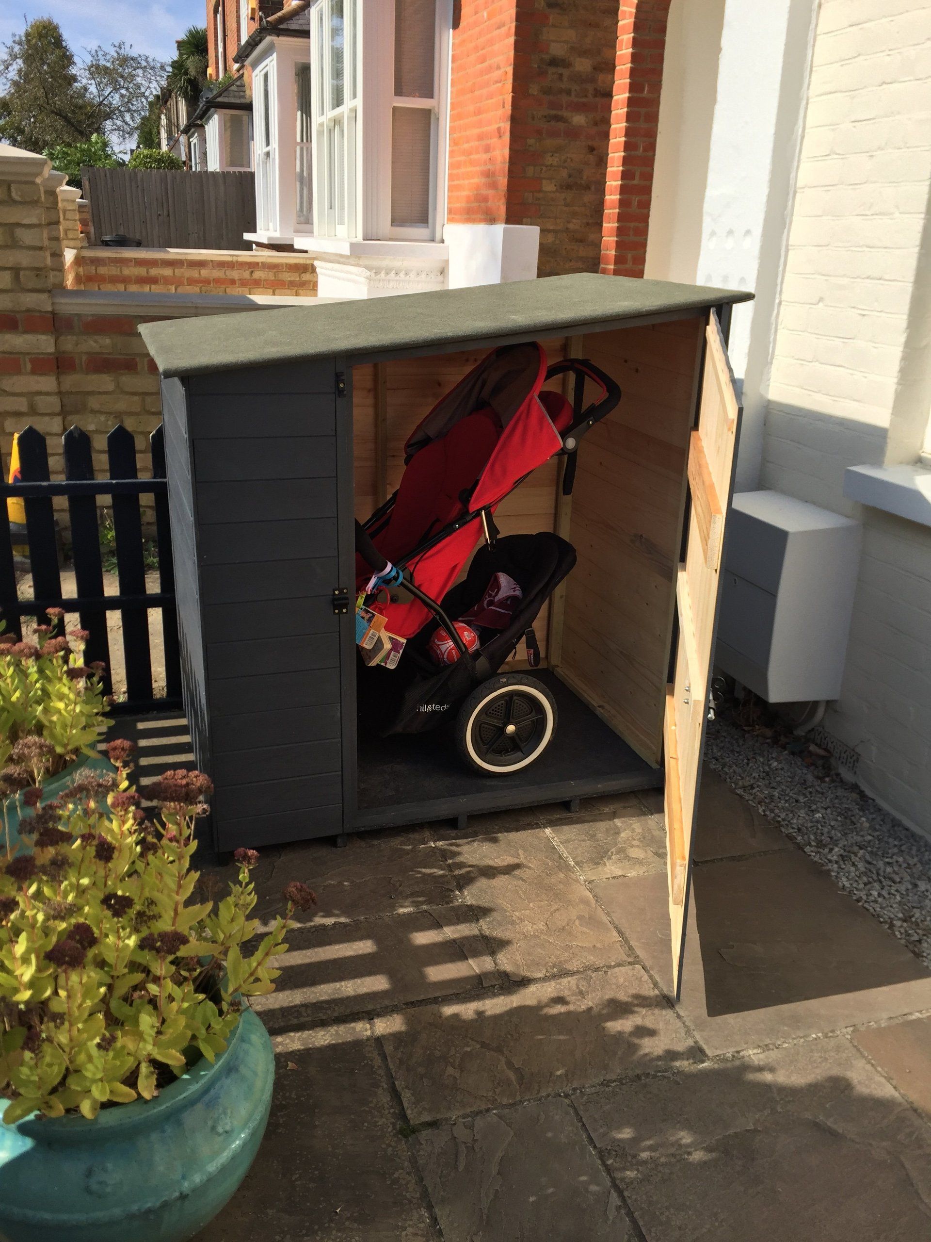Pram shed with side opening door.