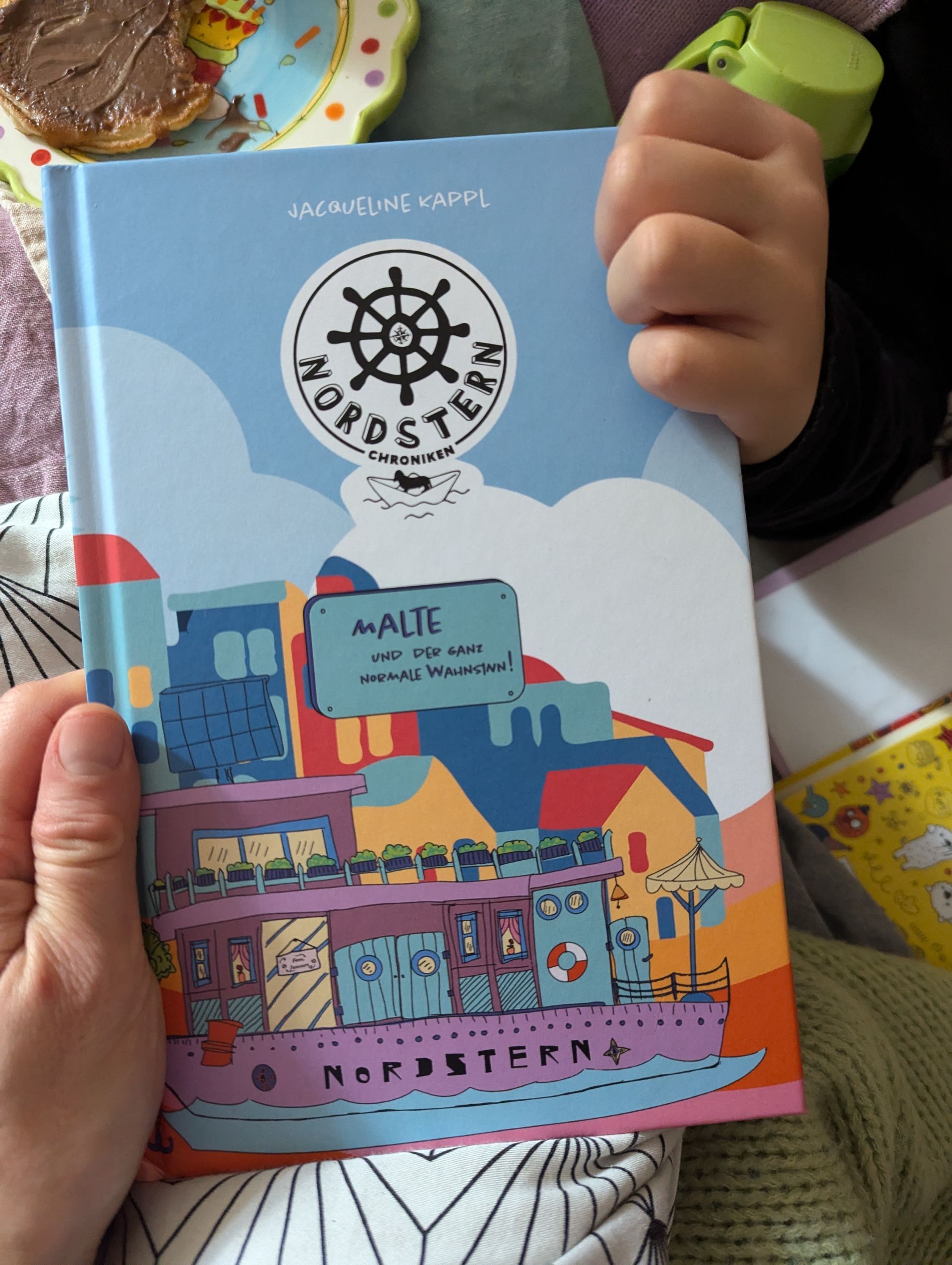 Authentisches Buchdesign für die „Nordstern-Chroniken Buchcover der Nordstern-Chroniken: Hausboot-Illustration in lebhaften Farben, gestaltet von JRK Studios Berlin