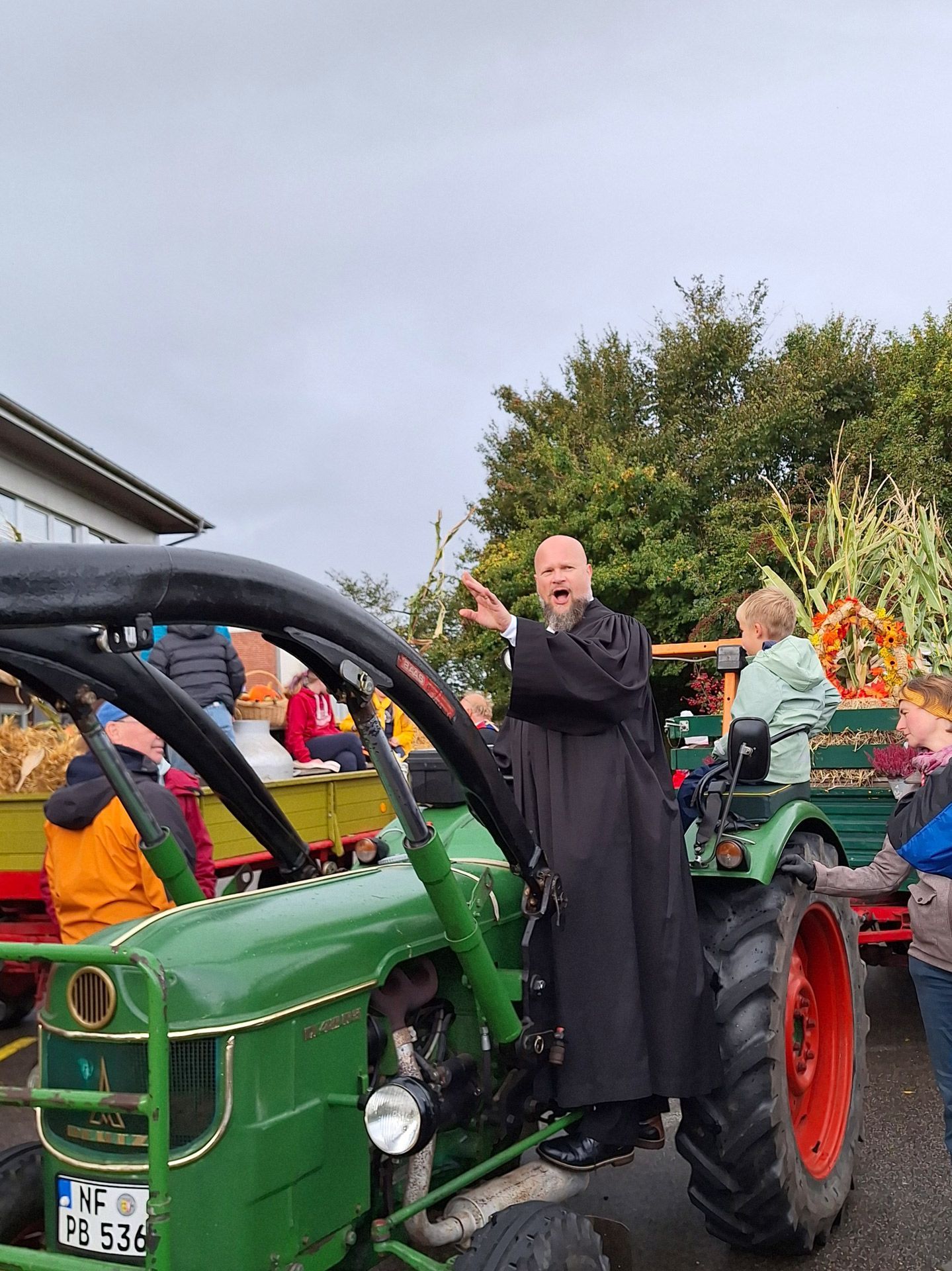 Erntedankfest. Das Bild zeigt den Pastor auf einem Traktor.