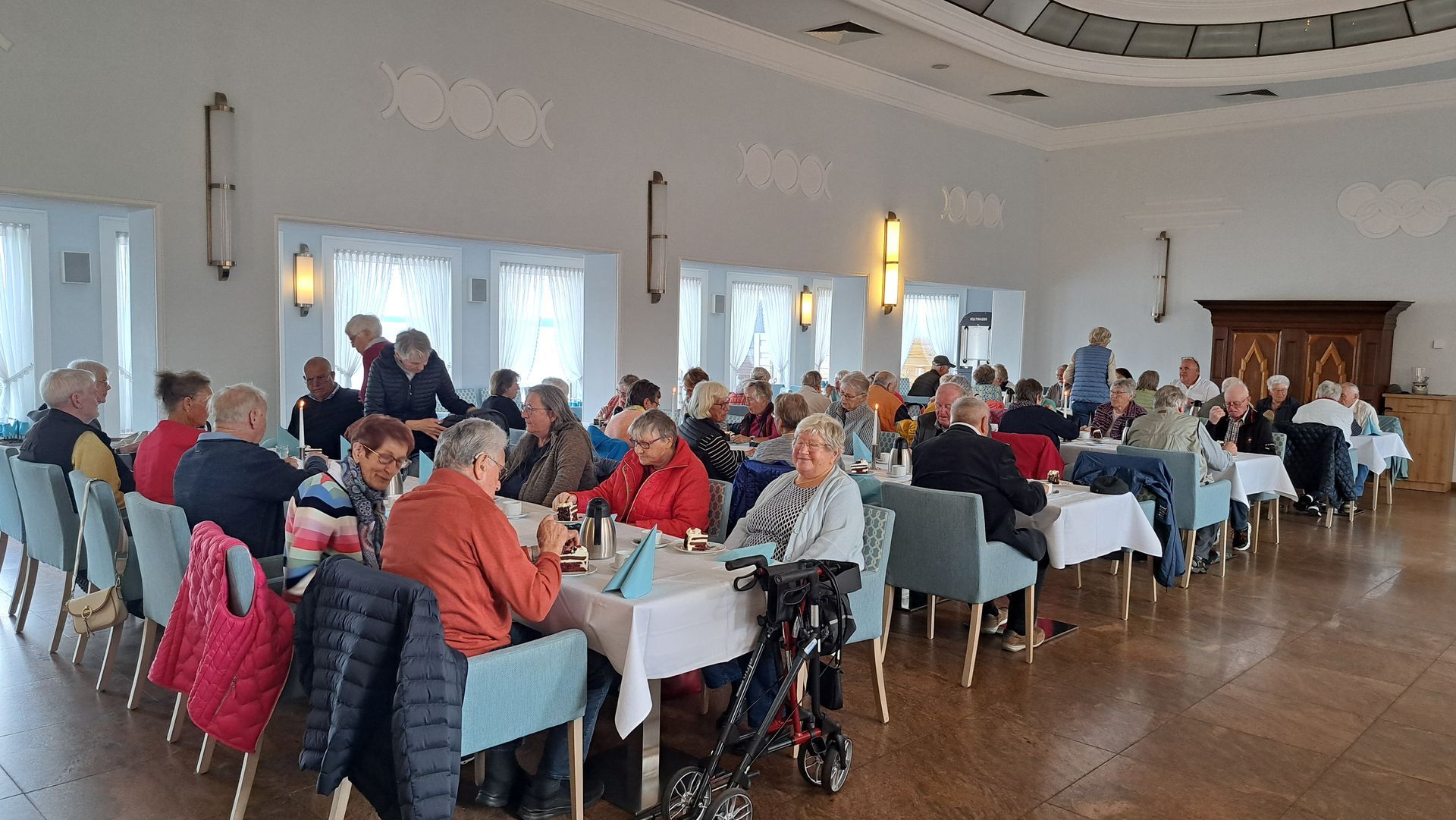 Gemeindeausflug. Das Bild zeigt die Teilnehmer bei Kaffee und Kuchen.