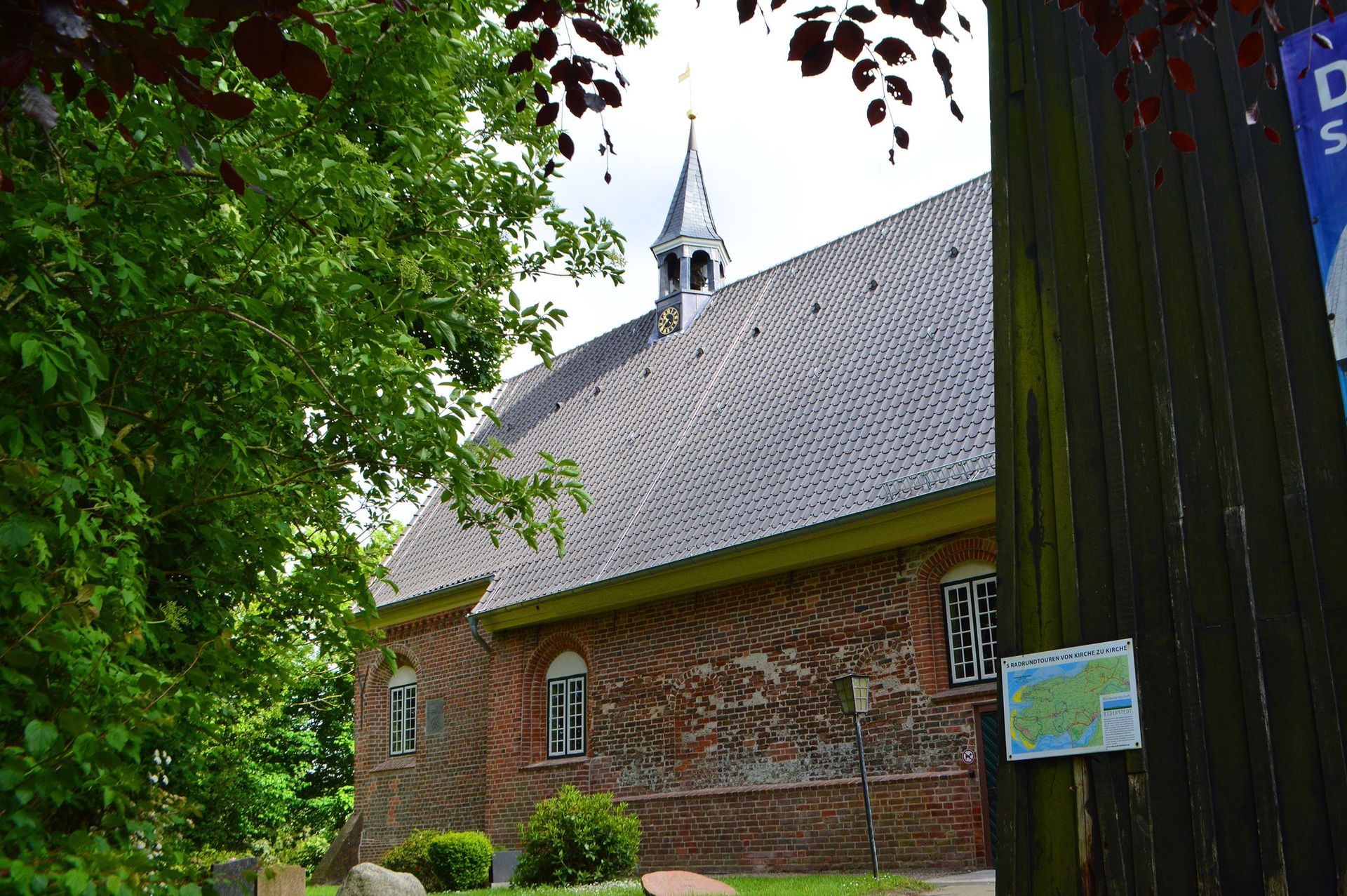 Das Bild zeigt die nördliche Ansicht der Kirche, rechts der Glockenturm.