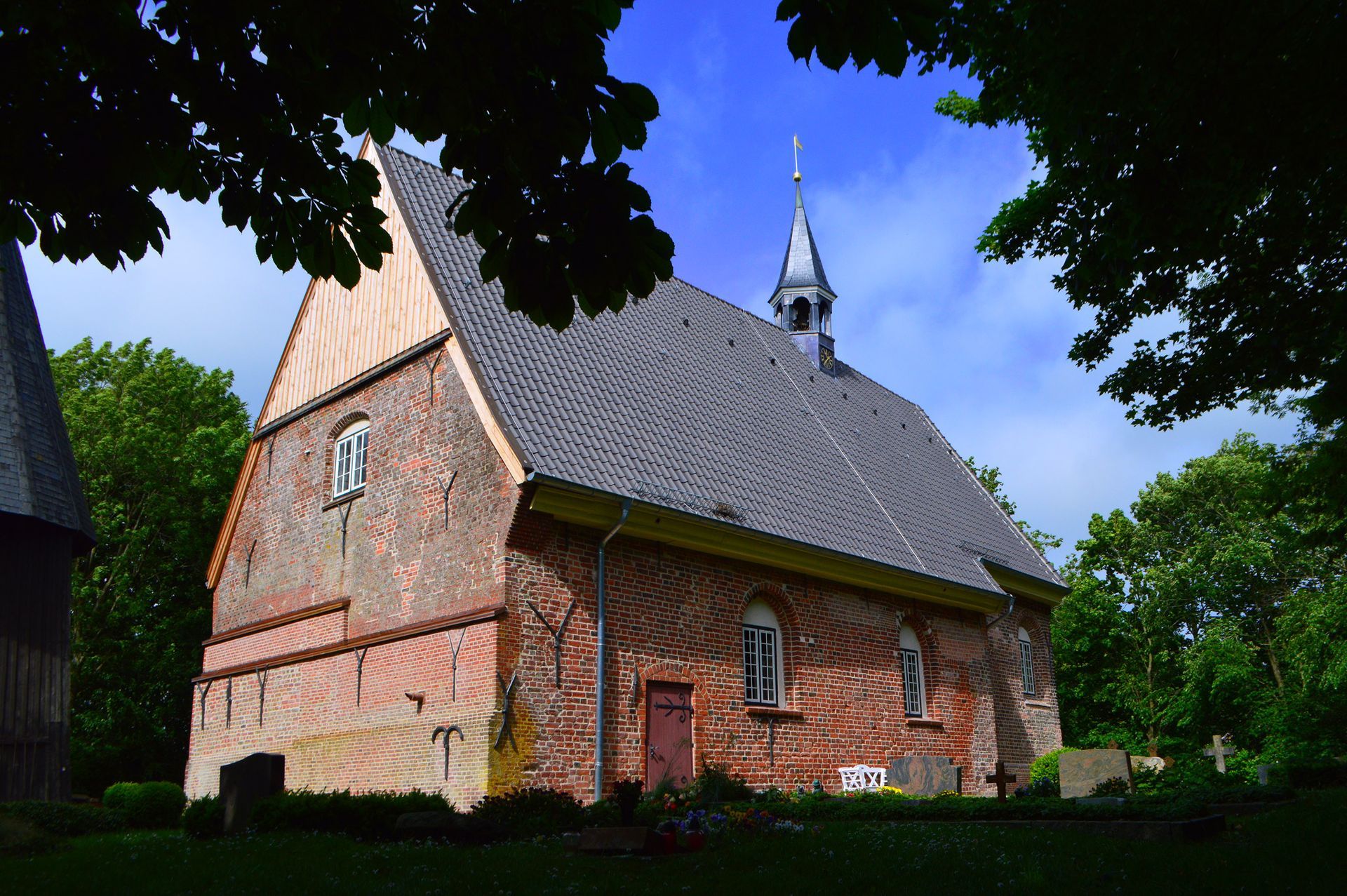 Das Bild zeigt die Kirche St. Katharina in Katharinenheerd an einem stürmischen Frühlingstag