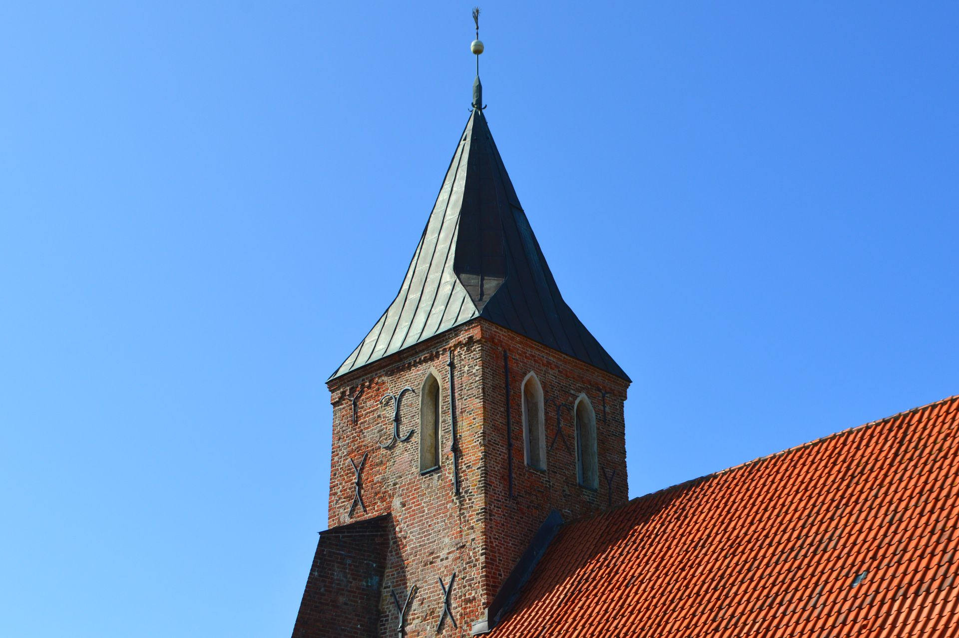 Kirchturm aus südwestlicher Perspektive. Der Turm ist der älteste Kirchturm des westlichen Eiderstedt.