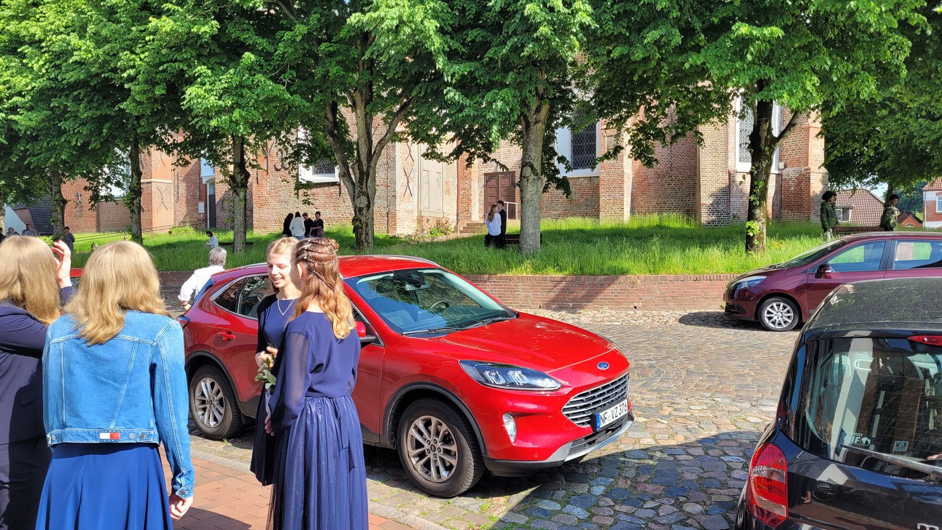 Konfirmation in Garding. Das Bild zeigt Konfirmanden und Leute vor der Kirche.