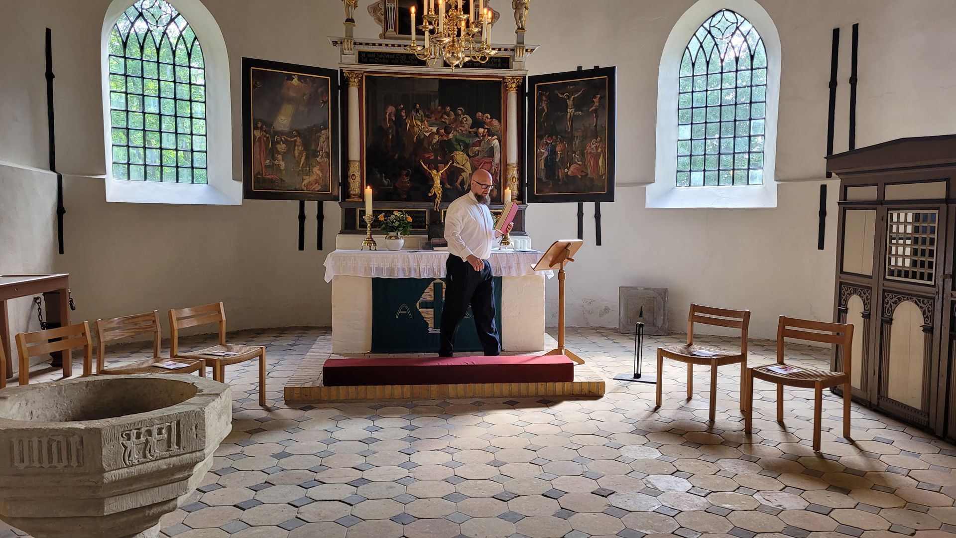 Konfirmation in Welt. Pastor bei Vorbereitungen vor dem Altar.