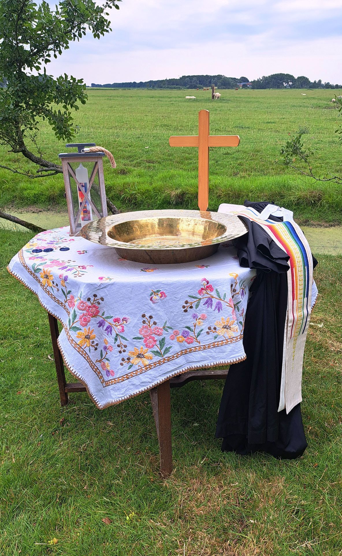 Das Bild zeigt das Taufbecken auf einem Tisch in einem Garten in Poppenbüll: Haustaufe