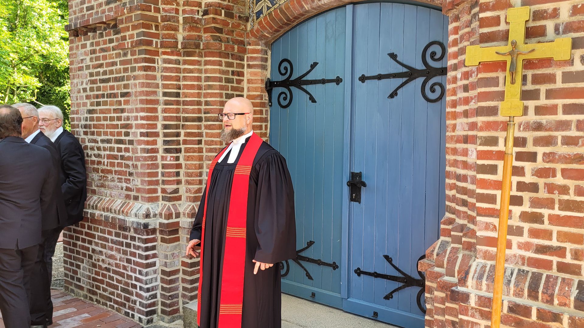 Das Bild zeigt Pastor Jörg Reglinski in der Predigt. Er hat die Augen geschlossen und die Arme ausgebreitet.