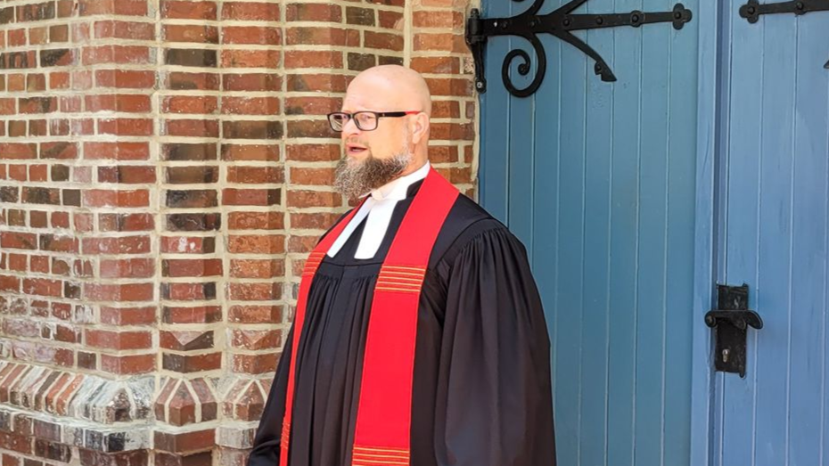 Pastor Jörg Reglinski Das Bild zeigt Pastor Jörg Reglinski. Er steht vor einem Altar.