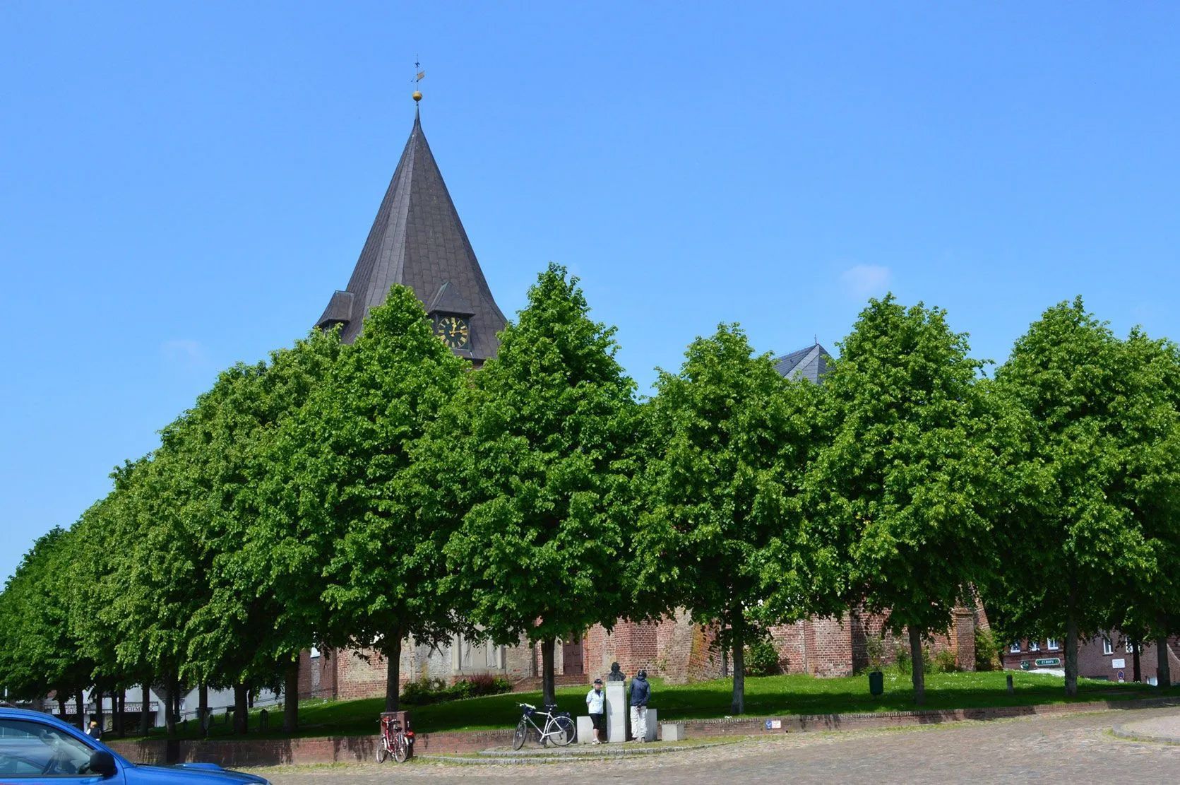 Kirche St. Christian vom Marktplatz von Bäumen umgeben.