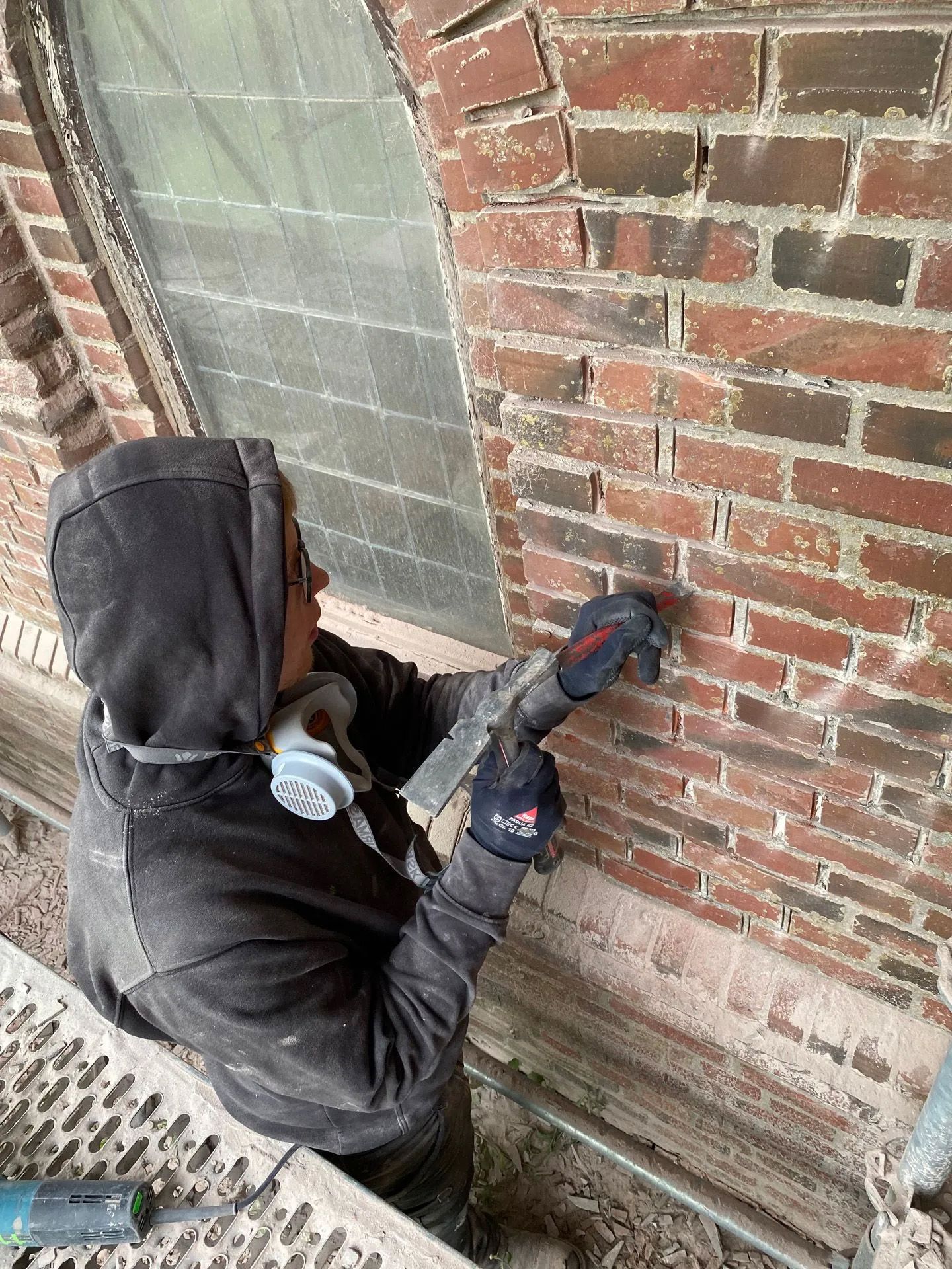 Ein Handwerker arbeitet an den Mauerwerksfugen