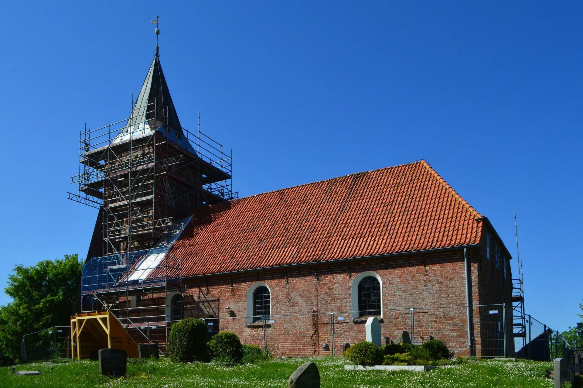 Kirchensanierung auf Eiderstedt
Das Bild Kirchturm mit einem Baugerüst