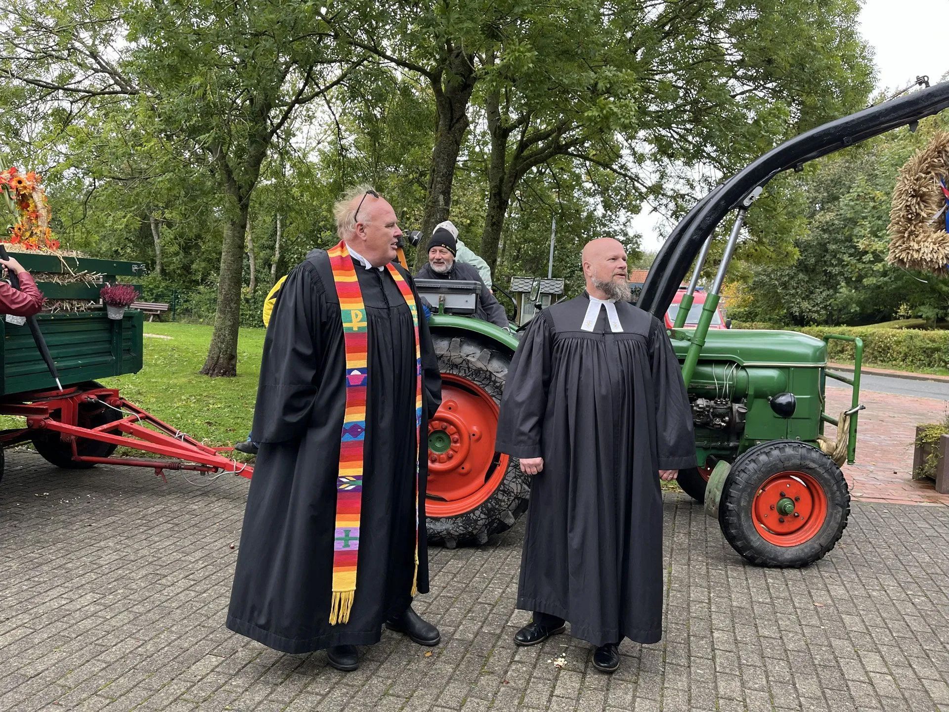 Erntedankfest Eiderstedt Mitte. Bild zeigt unsere Pastoren vor einem Traktor