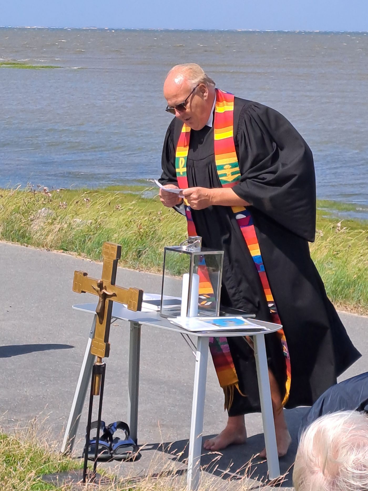 Deichtaufe in Stufhusen in Westerhever mit Pastor Knippenberg Deichtaufe. Der Pastor bereitet sich vor und ließt in seinen Notizen.