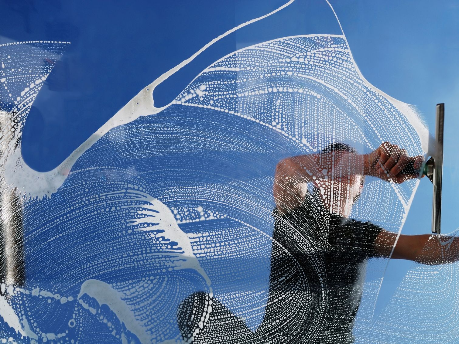 A man cleaning a window with traditional tools