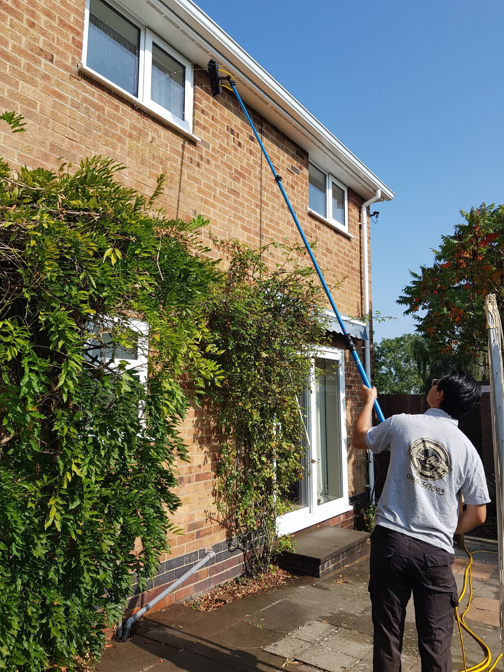 LDP Window Cleaning Ltd staff cleaning windows with a water fed pole