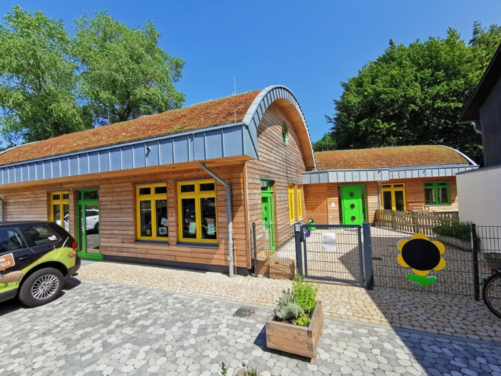 Ökologisches Bauen, weiter zum BV Hofkita „Nachhaltiger Neubau der Hofkita in Flensburg: Ökologische Holzbauweise mit Gründach und farbenfrohen Akzenten von Architektur Theet.“