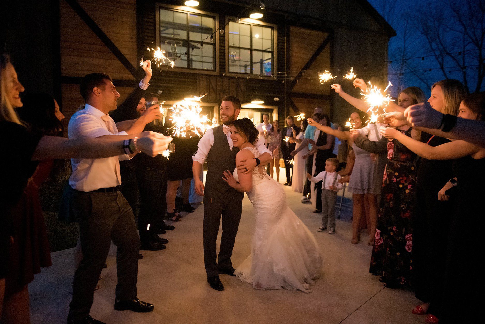 Sparkler exit at Union 12 wedding reception, a Fort Wayne wedding venue, with newlyweds walking through glowing sparklers outside the front doors β a magical end to their celebration.