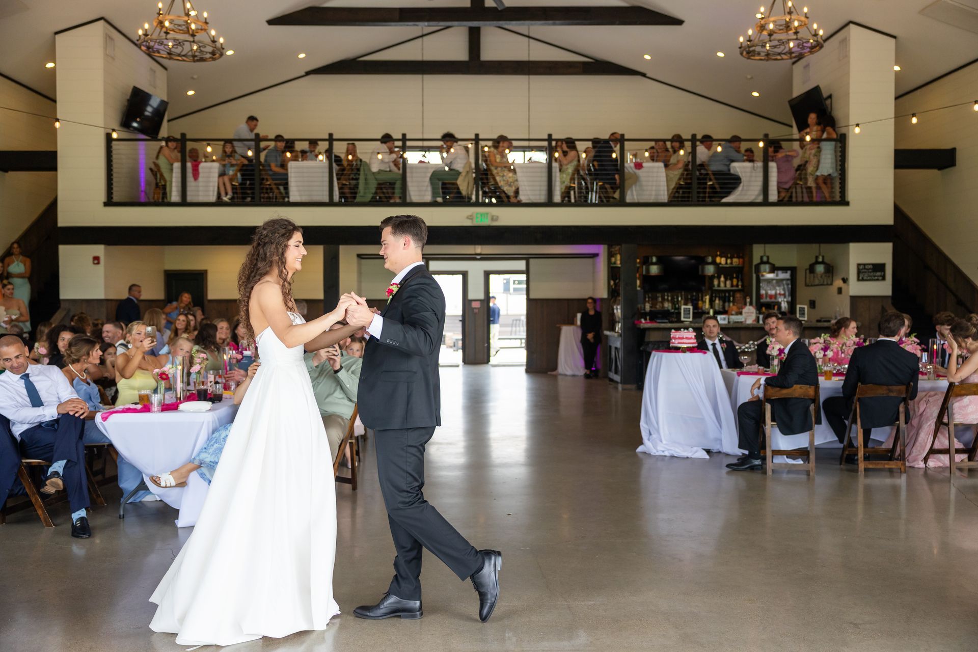 Bride and groom dancing at wedding reception. Reception area at Union 12 Fort Wayne wedding venue decorated with elegant string lights