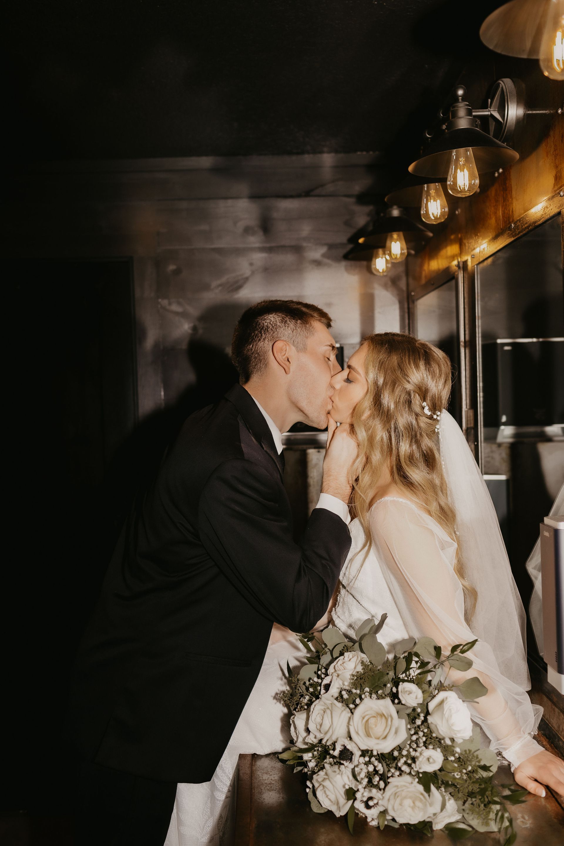 Fun wedding photo of the couple inside the Union 12 men’s restroom, highlighting the custom-built sink and rustic design touches.