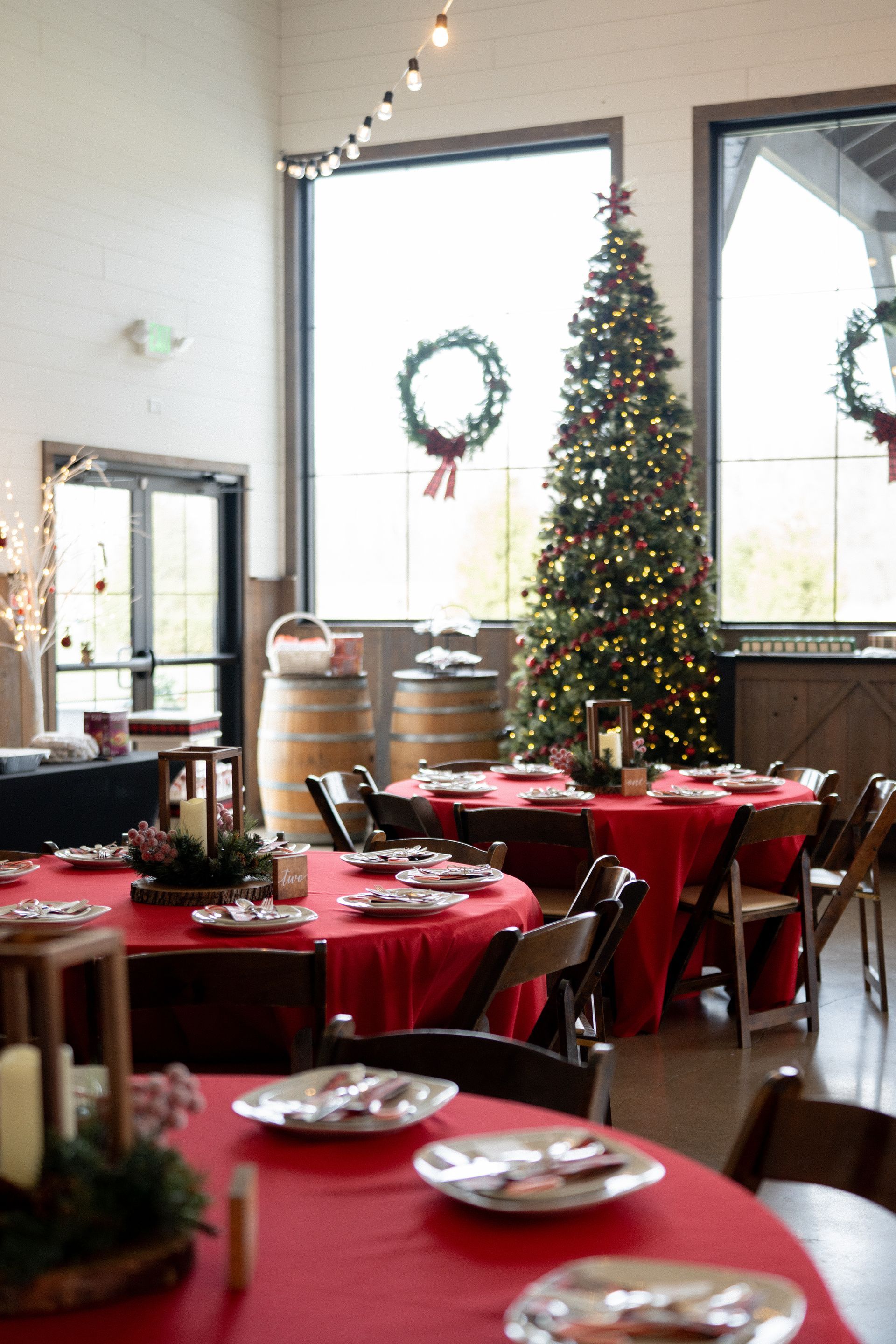 A beautifully decorated Christmas-themed wedding reception at Union 12, featuring elegant holiday accents such as pine garlands, and festive berries and green florals. Winter wedding decor at Fort Wayne wedding reception.