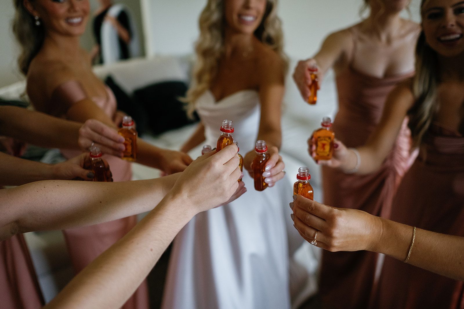 Bridesmaids clinking shot glasses in a joyful toast, celebrating together with smiles and laughter at Union 12 in Columbia City Indiana
