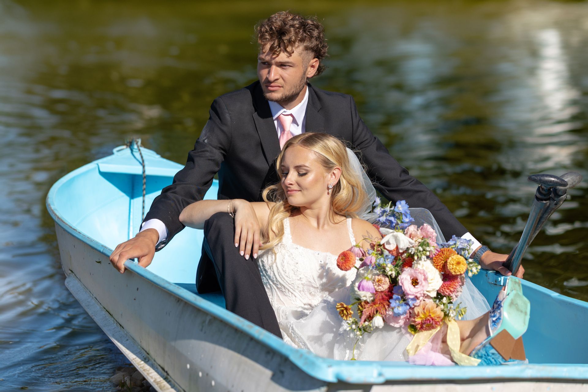 Bride and groom in rowboat on wedding day at Fort Wayne Wedding Venue in Columbia City Indiana