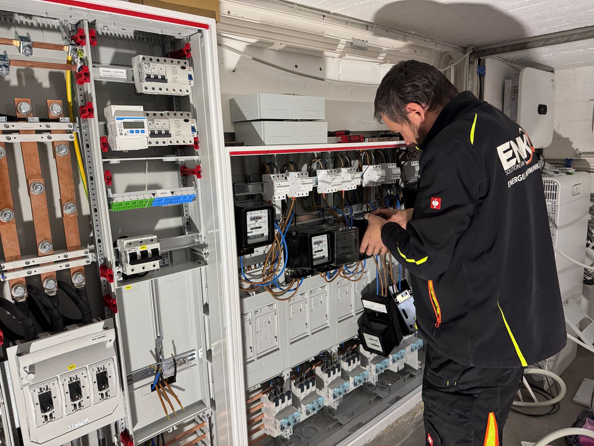 Techniker von Enko Solutions GmbH arbeitet an einem Zählerschrank.
