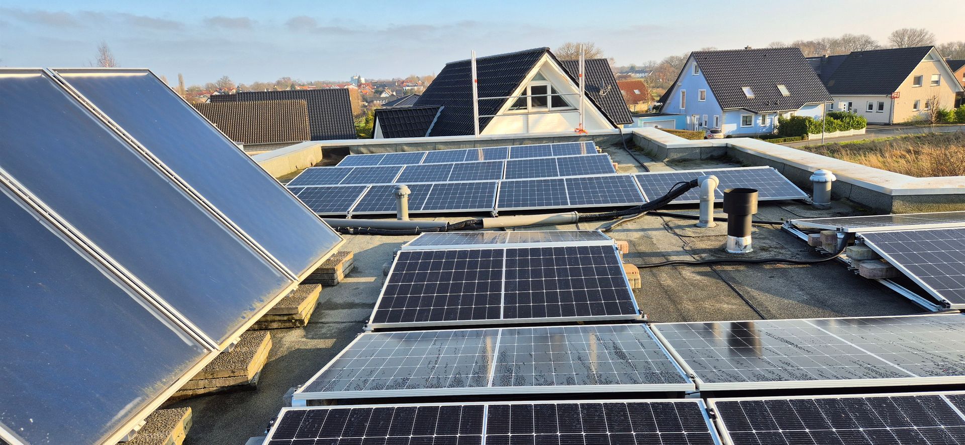 Nahaufnahme der Solarpaneele auf dem flachen Dach eines Gebäudes, die zur Energiegewinnung aus Sonnenlicht installiert sind.