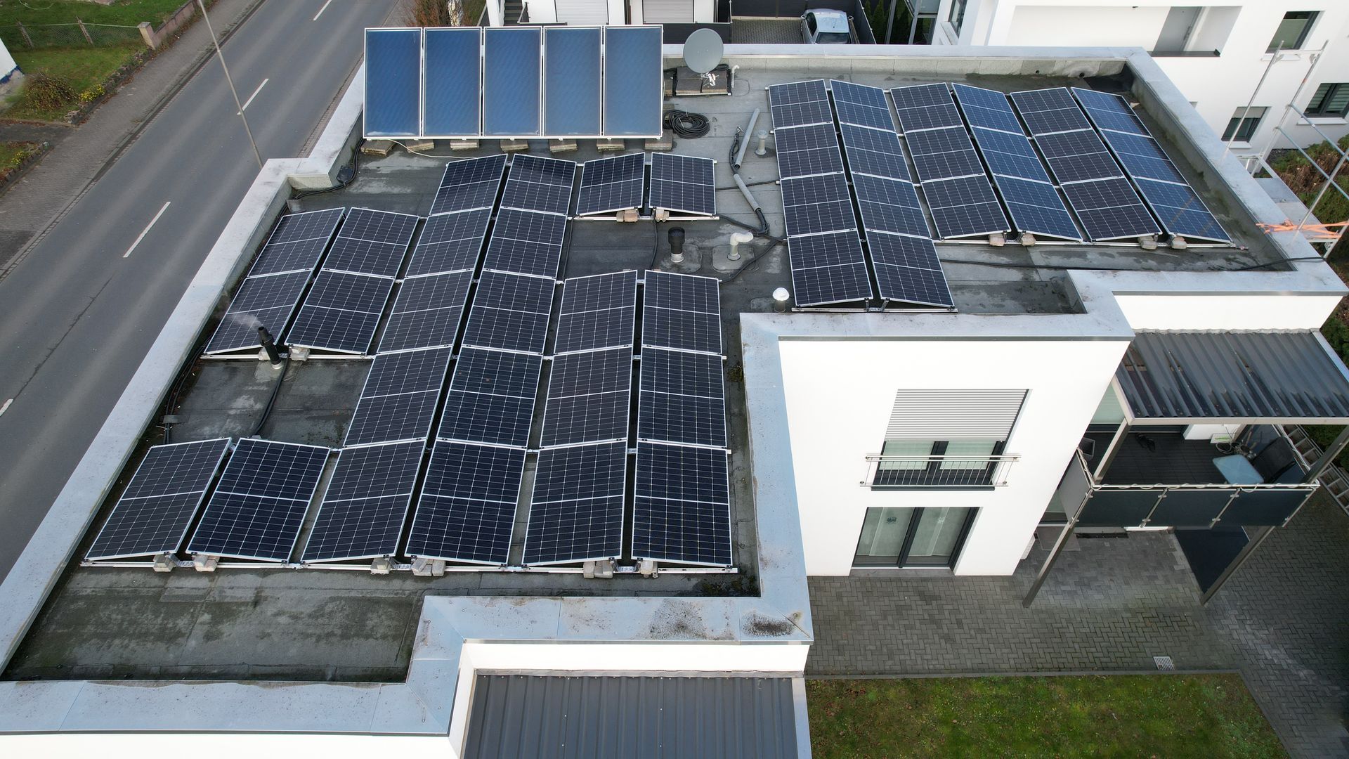 Solaranlage auf dem flachen Dach eines Gebäudes, die mehrere Solarpaneele in Reihen anordnet