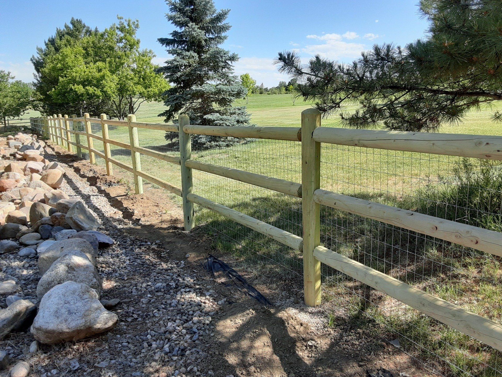 Three-rail dowel fencing with dog wire.