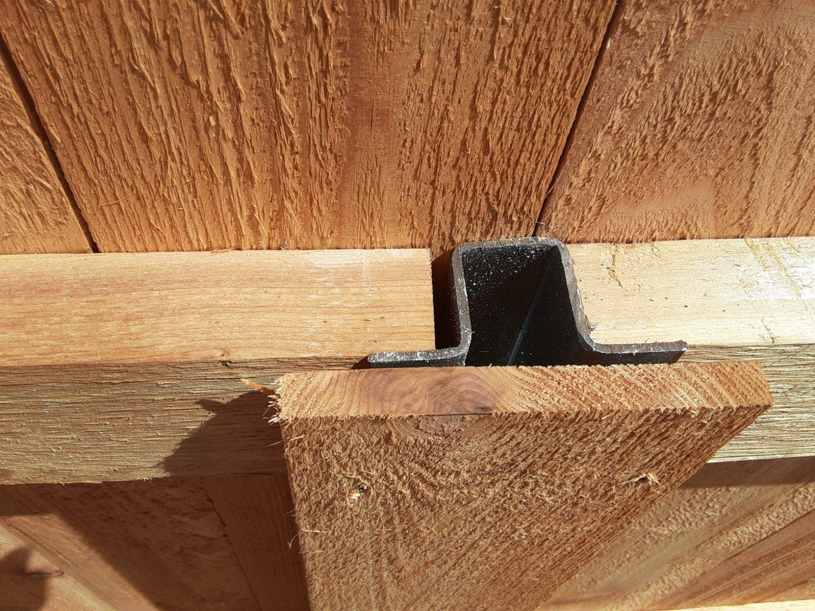 PostMaster steel fence post with back picket covering post.