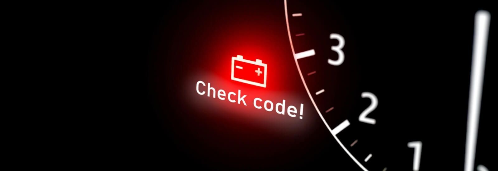 Close-up of a car dashboard showing a glowing battery warning light – indicating a potential battery