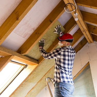 Man Installing Plywood Behind Foam Board Insulation
