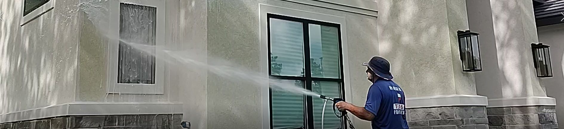 house washing a white home with green algae, with our low pressure soft wash system in Magnolia TX