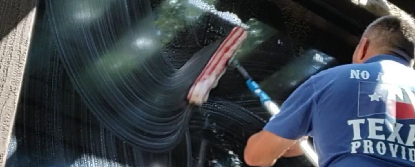 cleaning a large bay window in The Woodlands Texas with a mop and squeegee really making these windows shine.