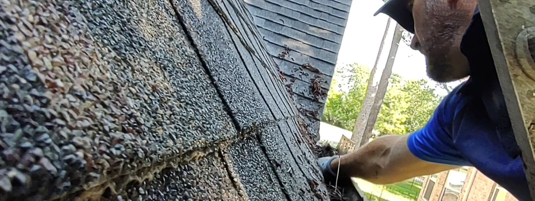 standing on a ladder while cleaning out gutters by hand in Magnolia TX