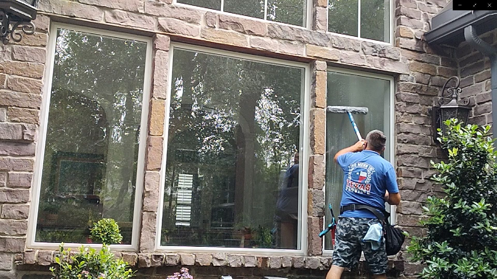 Detail-oriented cleaning of large casement windows by All Git Out Services in Magnolia, TX.