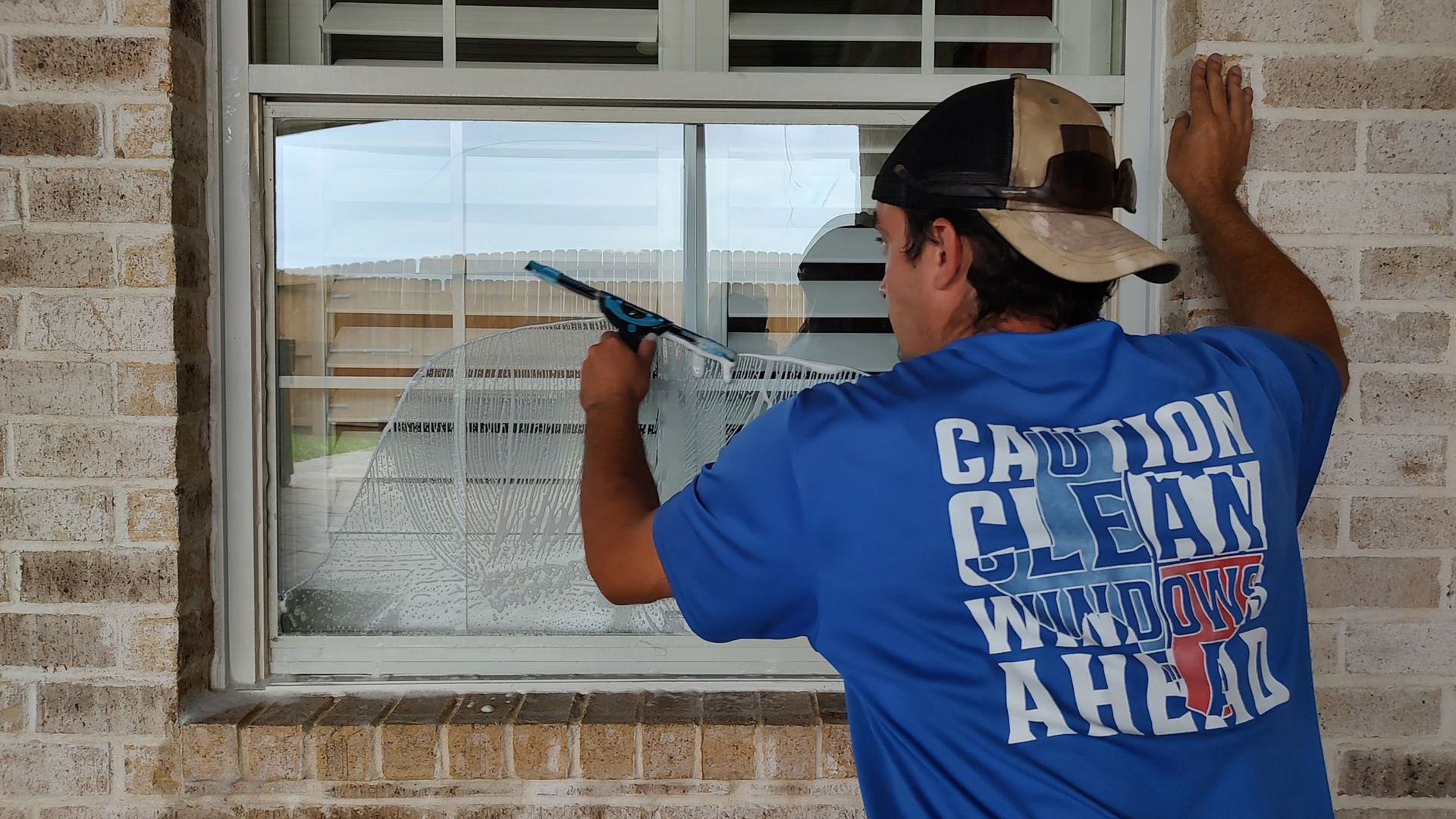 All Git Out Services using a squeegee for a spotless clean. Detailed window cleaning in Magnolia, TX removes all dirt.